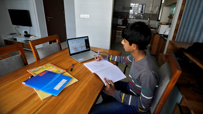 A student makes notes as he attends an online class at his home after Gujarat government ordered the closure of schools and colleges across the state amid coronavirus disease (COVID-19) fears, in Ahmedabad