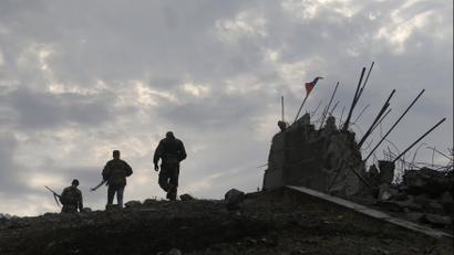 Pro-Russian separatists walk at a destroyed war memorial on Savur-Mohyla, a hill east of the city of Donetsk, August 28, 2014