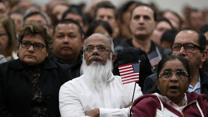 Immigrants participate in a naturalization ceremony to become new U.S. citizens