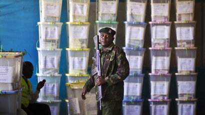 An officer of the prisons service helps to carry ballot boxes for stacking after their results were tallied, at a vote tallying center in Nairobi, Kenya Tuesday, March 5, 2013. With about a third of ballots counted provisional results showed Deputy Prime Minister Uhuru Kenyatta, who faces charges at the International Criminal Court, taking an early lead Tuesday as votes were counted the day after the country's presidential election.