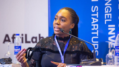 A seated Anna Ekeledo speaking at an event