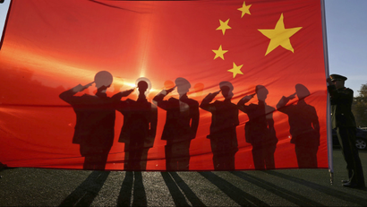 Retired paramilitary policemen, who conduct the daily national flag raising and lowering ceremony on Tiananmen Square, salute to a Chinese national flag during a farewell ceremony in Beijing, November 24, 2014.
