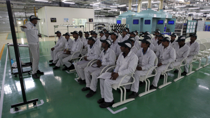 An instructor teaching newly appointed workers during a media tour to the newly inaugurated Honda Motorcycle &amp; Scooter India plant at Vithalapur