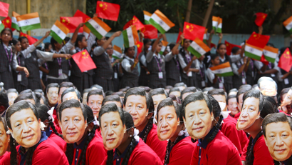 Students wear masks of China's President Xi Jinping as other waves national flags of India and China, ahead of the informal summit with India’s Prime Minister Narendra Modi, at a school in Chennai