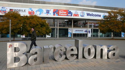 Man walks past sculpture in front of entrance of Mobile World Congress in Barcelona