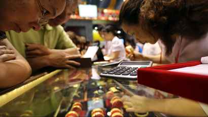 Chinese customers buy gold ornaments at a stand during a gold fair in Guangzhou, south Chinas Guangdong Province, 23 June 2013. Gold fell below $1,200 on Friday (28 June 2013) to its lowest since August 2010 before recovering, and is on track to post its worst quarter since at least 1968 on persistent worries over the U.S. Federal Reserves plan to wind down its monetary stimulus. Bullion has taken a beating since the beginning of last week, losing as much as 15 percent, or about $200 an ounce, after Fed Chairman Ben Bernanke laid out a strategy to roll back the banks $85 billion monthly bond purchases on the back of a recovering economy. The lower prices have failed to boost physical demand in Asia, traditionally the biggest buyer of gold, and investors have continued to flee exchange-traded gold funds. Prices initially failed to find support even after markets in China, the worlds second-biggest gold consumer, opened but saw some gains after some bargain-hunters emerged.(Imaginechina via AP Images