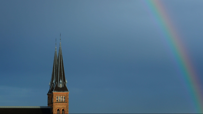 A rainbow appears next to the spires of Familienkirche church in Vienna