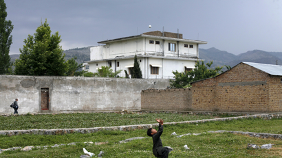A boy plays with a tennis ball in front of Osama bin Laden's compound in Abbottabad in this May 5, 2011 file picture. Osama bin Laden was killed almost a year ago, on May 2, 2011, by a United States special operations military unit in a raid on his compound in Abbottabad.