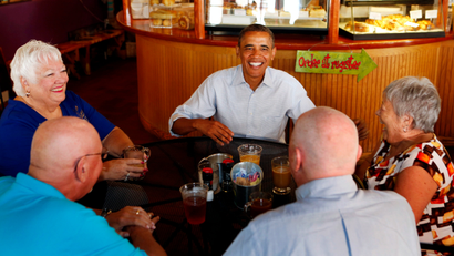 U.S. President Barack Obama eats with senior citizens inside the Ossorio Bakery and Cafe while campaigning in Cocoa, Florida, September 9, 2012. From L-R are: Jan Clark, Jerry Clark, Obama, John Hill, and Shirley Hill.
