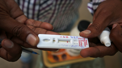 A health worker shows a malaria rapid test kit after collecting blood sample from a resident during a drive to prevent the spread of mosquito-borne diseases in Ahmedabad