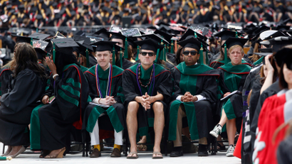A student in flip flops and shorts (C) watches as U.S. President Barack Obama (not pictured) receives an honorary degree during the spring commencement ceremony at Ohio State University in Columbus, May 5, 2013. REUTERS/Jason Reed (UNITED STATES - Tags: POLITICS EDUCATION SOCIETY TPX IMAGES OF THE DAY) - RTXZBLI