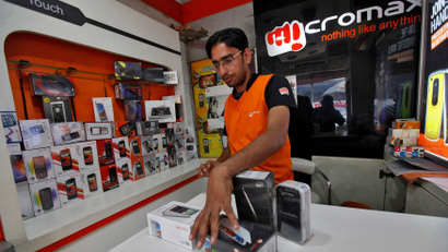 A worker displays a Micromax mobile phone inside a store in Kolkata
