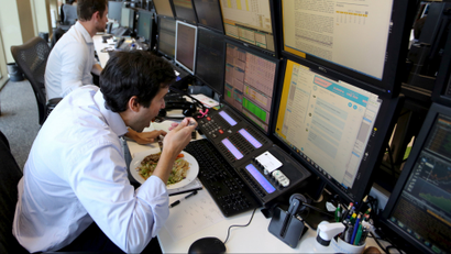 A trader eats lunch at his desk at a brokerage in Sao Paulo, Brazil.