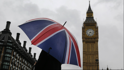A woman holds a Union flag umbrella in front of the Big Ben clock tower