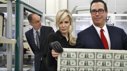 Treasury Secretary Steven Mnuchin, right, and his wife Louise Linton, hold up a sheet of new $1 bills.