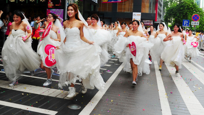 Women in wedding gowns participate in a brides' race event organized by a shopping mall to celebrate the upcoming Qixi Festival in Guangzhou
