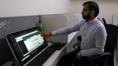Rohitash Repswal shows a software tool that appears to automate the process of sending messages to WhatsApp users, on a screen inside his office in New Delhi