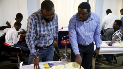 A picture of two staff looking over a document on a table at a Nigerian company