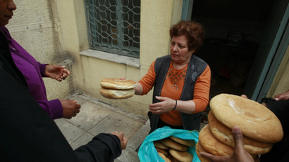 A volunteer distributes loaves of bread at the Agia Zonis Orthodox church in Athens.