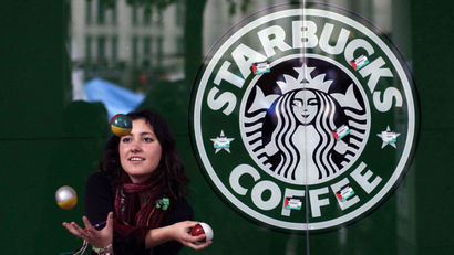 A French supporter of the Occupy London Stock Exchange movement who gave her name as Estelle de Marseille, stating that it's the name she goes by but not her real name, juggles outside a branch of the Starbucks coffee chain beside the protest camp outside St Paul's Cathedral London, Thursday, Oct. 27, 2011