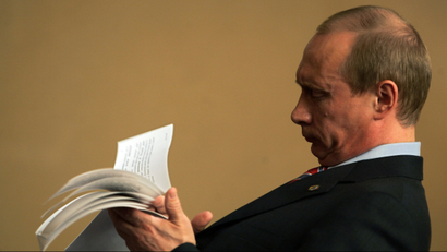 Russian President Vladimir Putin checks his notes before a meeting.