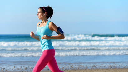 Woman running on beach with earphones