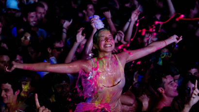 A reveler reacts during a glow paint party in the early hours on Saturday June 23, 2012. Around a thousand youths danced to techno music while spraying each other with paint, while the organizers sprayed the party goers from the stage. AP Photo/Paul White)