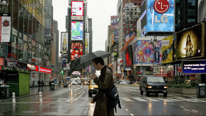 man walking through times square surrounded by advertisements