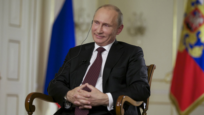 Russian President Vladimir Putin smiles during an interview.