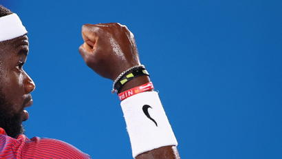 Frances Tiafoe holds up his Nike-clad fist in victory.