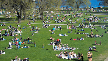 Crowds sun themselves in a park