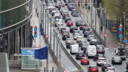 Many cars on a road next to a building and an EU flag in Brussels, Belgium