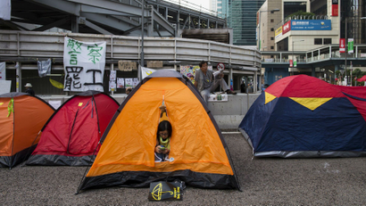 An Occupy Central protester looks her phone in her tent at a protest site in Admiralty near the government headquarters in Hong Kong October 16