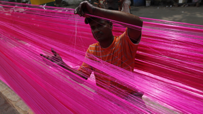 A man checks polyester thread kept for drying to make artificial garlands ahead of the Diwali festival in the western Indian city of Ahmedabad October 11, 2011. Artificial garlands are sold in large numbers during Diwali, the annual Hindu festival of lights, when people buy these to decorate their homes.