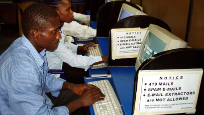 Nigerians surrounded by warning signs about sending fraudulent e-mail wait to use the Internet in an Internet cafe in Lagos, Nigeria Sunday, July 17, 2005. Nigerian police say they've scored results in a crackdown launched by President Olusegun Obasanjo's government in the past three years on such crime - which had grown to the point that it is associated with Nigeria all over the world - but new scammers are appearing and evolving new ruses to both trap victims and evade detection.