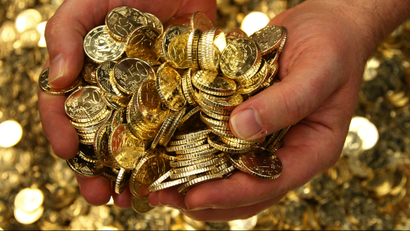 hands holding a pile of gold coins