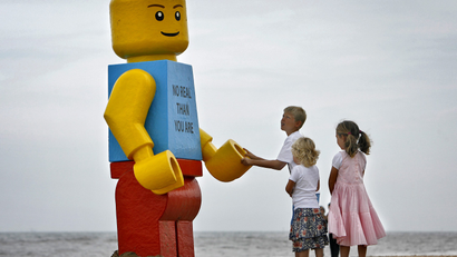 children play with giant Lego man