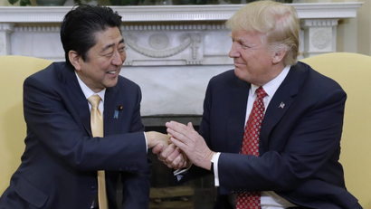 President Donald Trump shakes hands with Japanese Prime Minister Shinzo Abe in the Oval Office.