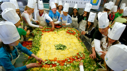 School children prepare a huge slice of bread at the start of a campaign promoting healthy lunch at school in Zwanenburg April 27, 2006. The giant sandwich measures 1.70 by 2.70 meters (5.6 by 8.9 feet). 40,000 school children in the Netherlands will get a free healthy lunch at school.