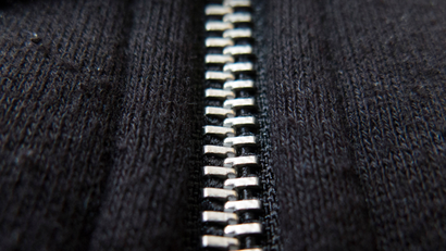 Close up of a zipper. A zipper, zip, fly or zip fastener, formerly known as a clasp locker, is a commonly used device for binding the edges of an opening of fabric or other flexible material, as on a garment or a bag. (Photo by In Pictures Ltd./Corbis via Getty Images)