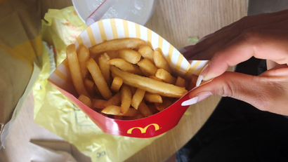 A McDonald's customer shows her french fries box at the fast-food chain McDonald's in New York