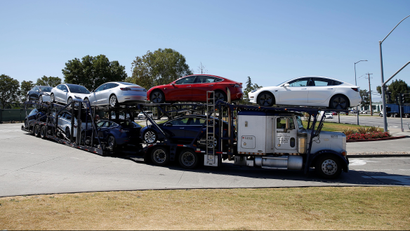 A car carrier trailer carries Tesla Model 3 electric sedans, is seen outside the Tesla factory in Fremont, California, U.S. June 22, 2018. REUTERS/Stephen Lam - RC1F02FCAB90