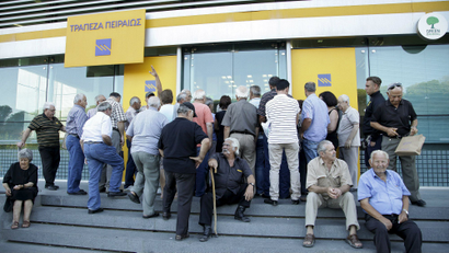 People wait to enter a Piraeus Bank branch at the city of Iraklio in the island of Crete, Greece July 20, 2015.