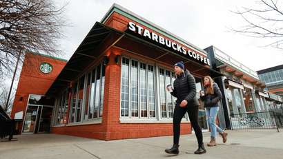 Two people walk past a Starbucks store in Buffalo, New York.