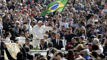 Pope Francis waves as he arrives to lead the weekly audience in Saint Peter's Square at the Vatican April 29, 2015.