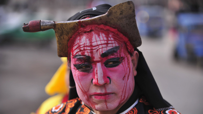 A folk performer with his face painted to appear as knife cuts, and wearing a knife prop on his head, takes part in a "Blood Shehuo" parade to celebrate the Lantern Festival on the last day of the Chinese Lunar New Year celebrations at Chisha village in Baoji, Shaanxi province February 6, 2012. "Shehuo" is common name of Chinese traditional activities consisting of folk performances in Northern China. The "Blood Shehuo" performers wear facial makeup to appear as being pierced by objects including axes, scissors and knives, featuring scenes of horror in traditional stories like Water Margin. This activity is held only in Baoji county and performed only during leap years. REUTERS/Rooney Chen