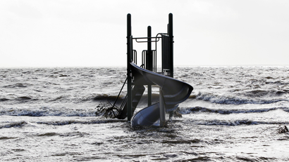 A playground apparatus stands surrounded by water pushed up by Hurricane Sandy in Bellport, New York, October 30, 2012. Millions of people across the eastern United States awoke on Tuesday to scenes of destruction wrought by monster storm Sandy, which knocked out power to huge swathes of the nation's most densely populated region, swamped New York's subway system and submerged streets in Manhattan's financial district. REUTERS/Lucas Jackson (UNITED STATES - Tags: ENVIRONMENT DISASTER) - GM1E8AU1UJ301