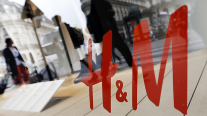 People walk past the window of a H&M store in Paris, France, August 24, 2015.