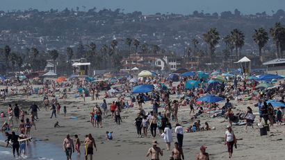 People crowd Ocean Beach in San Diego, California.