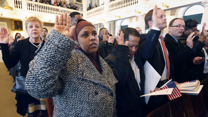 Hawd Ahmed, front left, who came from Somalia, takes the oath of U.S. citizenship during a naturalization ceremony in Boston, Thursday, April 2, 2015. Nearly 400 people from dozens of countries ranging from Albania to Zimbabwe took part in the ceremony.